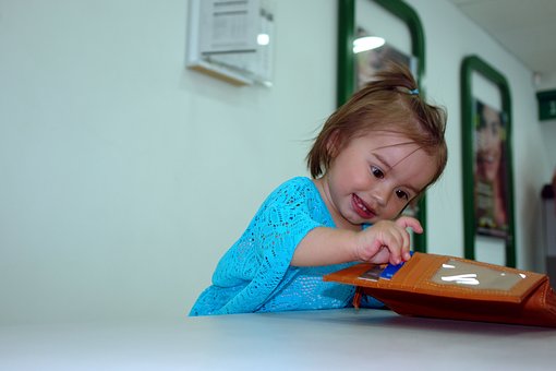 Une fille qui joue avec le porteefeuille de papa